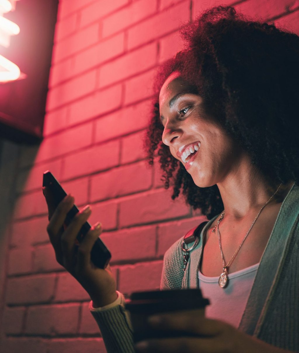 Black woman, phone and night in city with smile on social media, app or communication on travel, to Black woman, phone and night in city with smile on social media, app or communication on travel, to